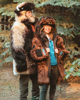 Man and woman wearing the great white buffalo wildcoat parka, and the classic brown buffalo coat parka