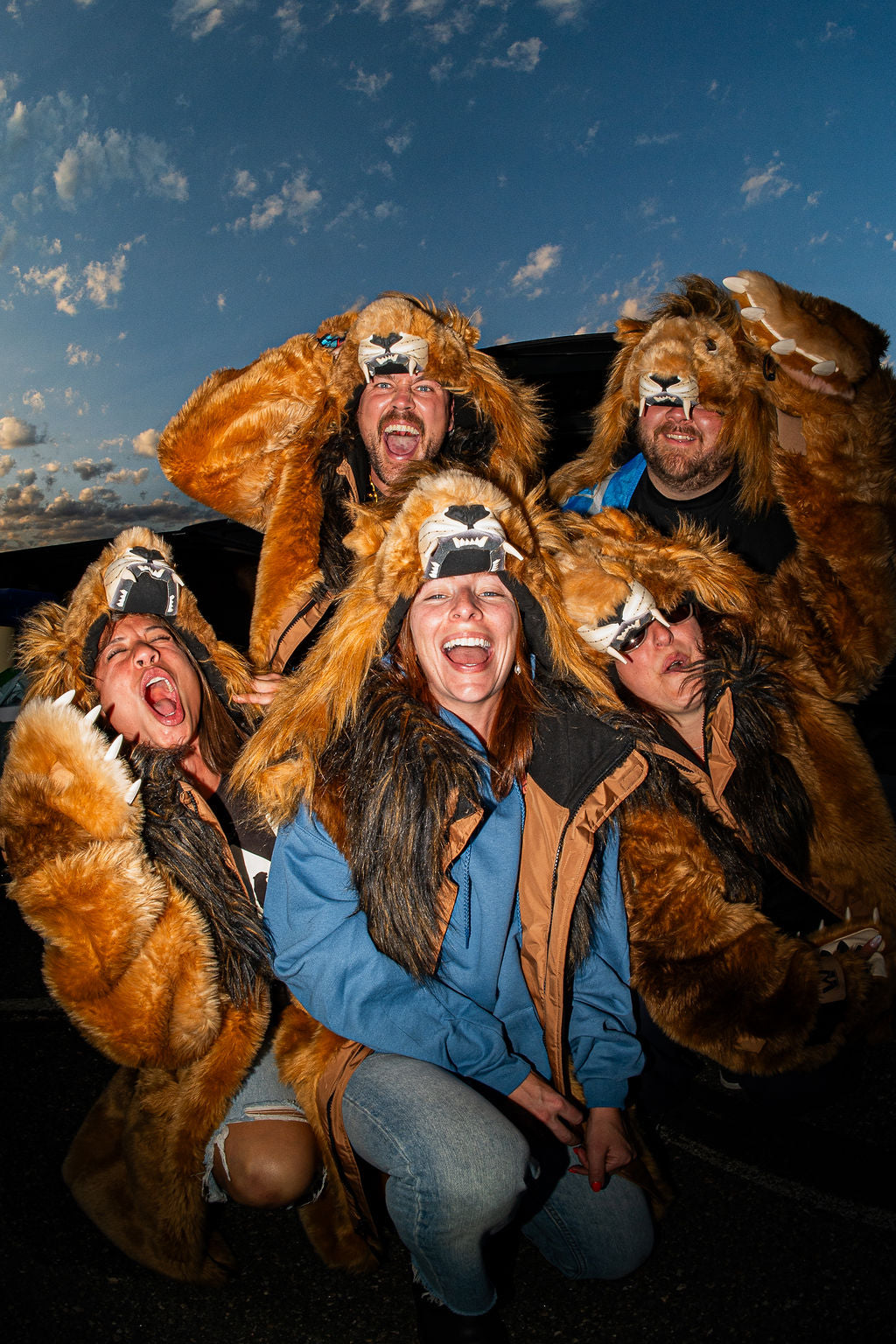Five detroit lions fans wearing wildcoat lion parkas at a tailgate celebrating