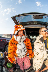Woman Cincinnati Bengals fan wearing the wildcoat orange bengal tiger bomber at a tailgate next to a man wearing the wildcoat white bengal tiger parka