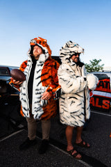 Two cincinnati bengal fans wearing white and orange faux fur wildcoats that look like tiger coats, celebrating at a tailgate
