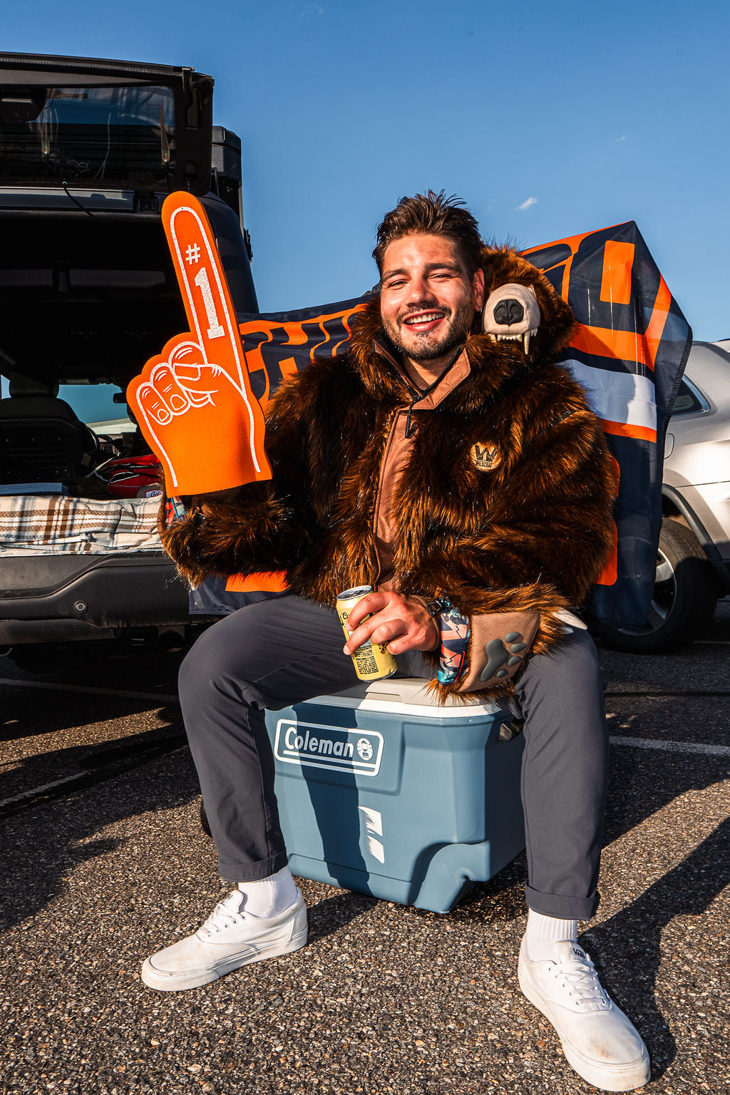 Chicago bears fan wearing the wildcoat grizzly bear bomber at a tailgate in chicago sitting on a cooler