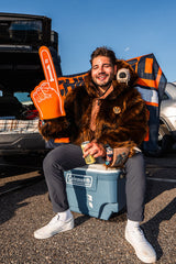 Chicago bears fan wearing the wildcoat grizzly bear bomber at a tailgate in chicago sitting on a cooler