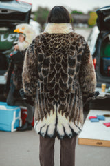 A person wearing a wildcoat v6 eagle coat with the hood removed, showing the detailed back plumage pattern of the eagle design.