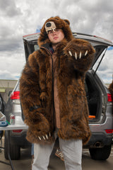 man wearing a faux fur grizzly bear parka coat at a chicago bears tailgate, pointing at the camera with his claws
