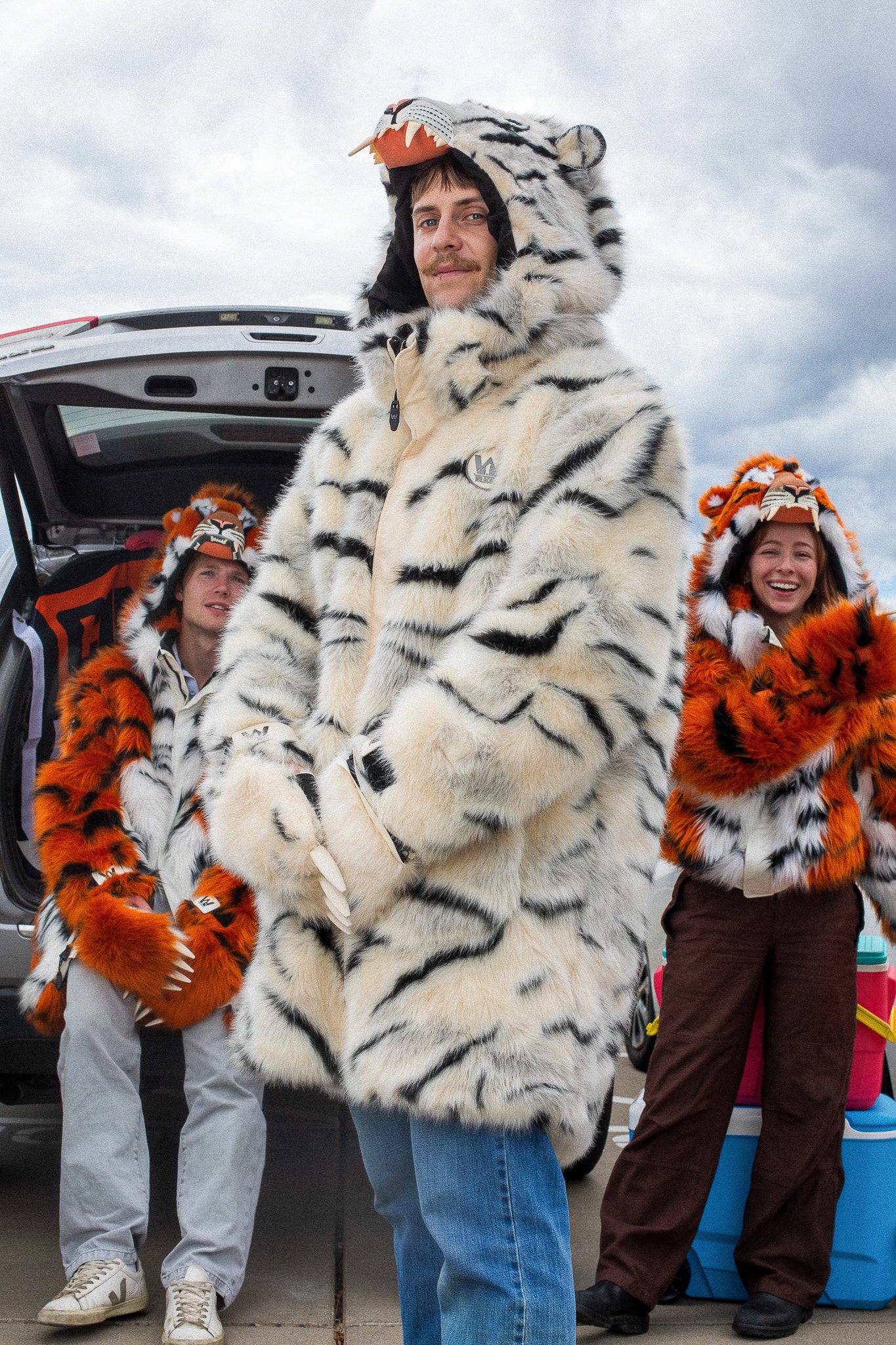 man wearing a wildcoat faux fur white bengal tiger coat with the hood up