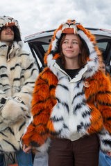 woman wearing a wildcoat faux fur orange bengal tiger bomber-cut coat / jacket. man on her left is wearing a white bengal tiger parka length faux fur coat 