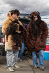 woman wearing a wildcoat v6 buffalo bison faux fur winter coat at a tailgate with a man in the next to her wearing the great white buffalo coat