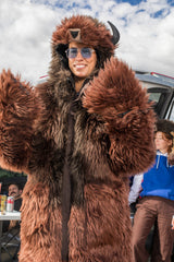woman wearing a wildcoat v6 buffalo bison faux fur winter coat at a tailgate with a woman in the background wearing the great white buffalo hood
