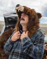 man wearing a faux fur grizzly bear hood helmet head cover at a tailgate