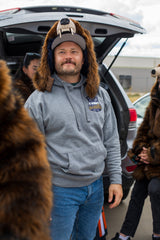 man wearing a faux fur grizzly bear hood helmet head cover at a tailgate
