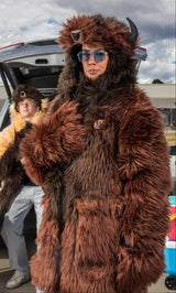 woman wearing a wildcoat v6 buffalo bison faux fur winter coat at a tailgate with a man in the background wearing the great white buffalo coat